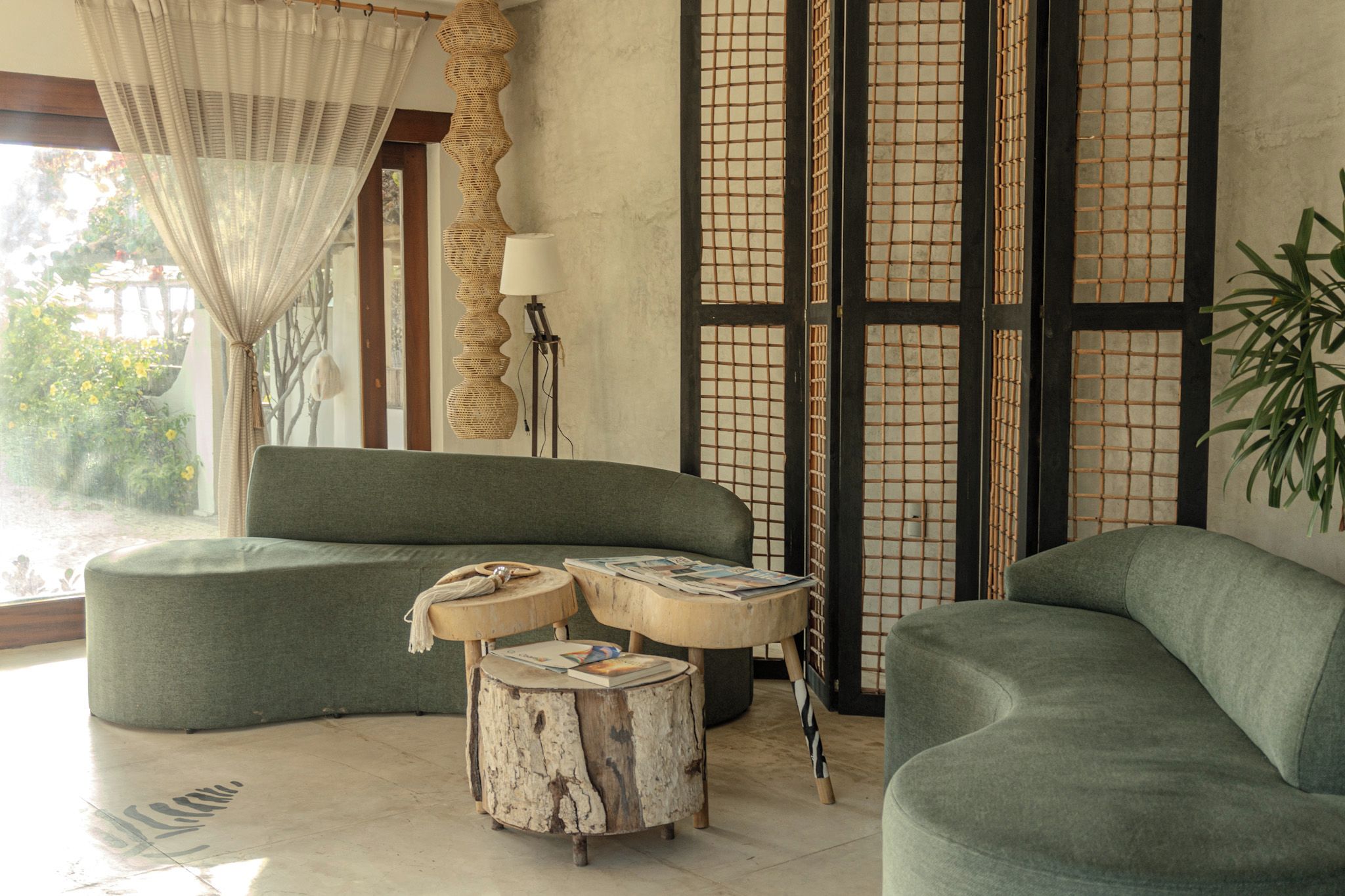 A modern living room with a green sofa, a wooden coffee table, and a floor lamp.