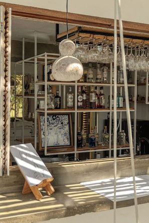 A storefront with a variety of liquor bottles and a framed artwork on display. - Zebra Boutique Hotel (Beberibe)
