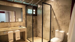 Uma casa de banho moderna com lavatório de mármore, cabine de duche com vidro e sanita.
