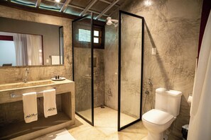 Une salle de bain moderne avec un lavabo en marbre, une douche à parois de verre et des toilettes.