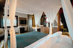 A bedroom with a bed, a TV, a desk, and a bathroom. - Zebra Boutique Hotel (Beberibe)