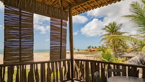 A wooden deck with a view of the beach and palm trees. - Zebra Boutique Hotel (Beberibe)