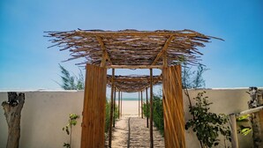 A wooden pergola structure with a clear view of the beach in the background. - Zebra Boutique Hotel (Beberibe)