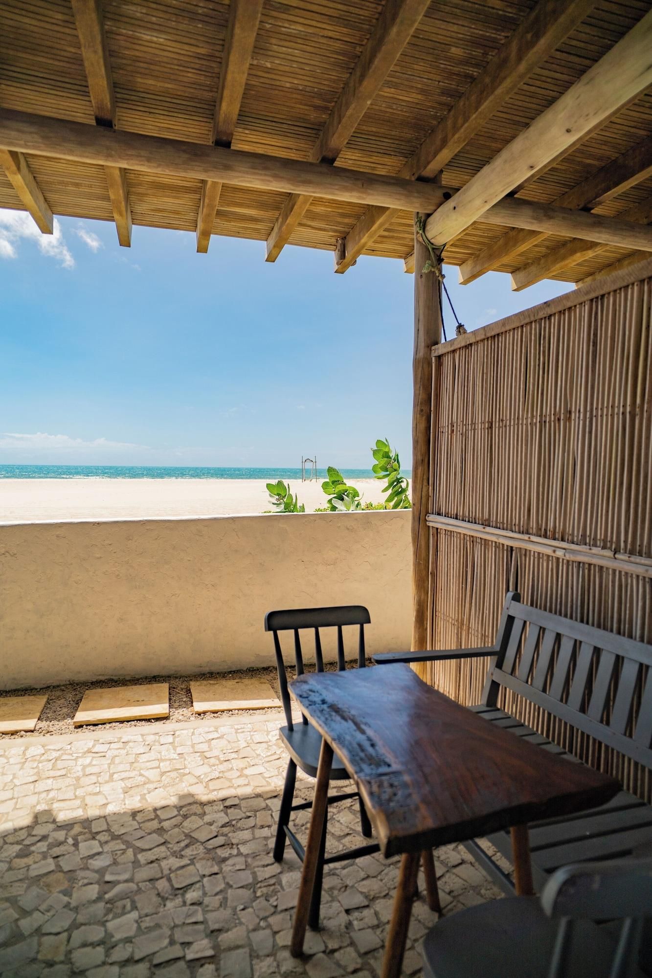 Un espacio de estar al aire libre techado con vista a la playa.