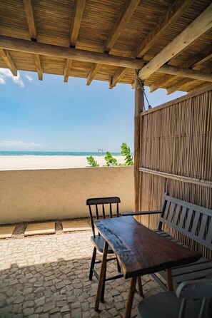A covered outdoor seating area with a view of the beach. - Zebra Boutique Hotel (Beberibe)