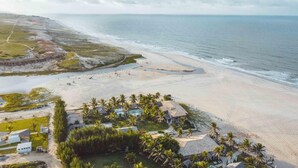 An aerial view of a beach resort with a swimming pool, palm trees, and beach huts. - Zebra Boutique Hotel (Beberibe)