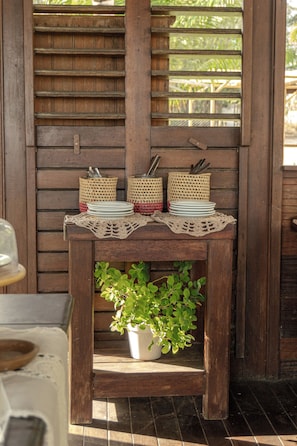 Ein Holztisch mit einer gewebten Tischmatte, zwei gewebten Körben und einem Blumentopf.