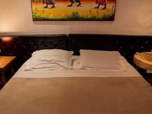 A bedroom with a bed, a headboard, a nightstand, and a round wooden table. - Zebra Boutique Hotel (Beberibe)
