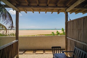Ein überdachter Außenbereich mit Blick auf einen Strand.