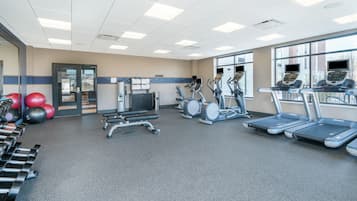 A gym with treadmills, elliptical machines, and free weights.