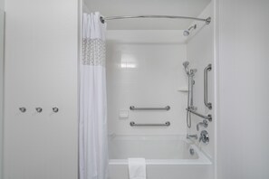 A modern bathroom with a walk-in shower, grab bars, and a white towel hanging on the wall. - Hampton Inn & Suites Newburgh Stewart Airport (Newburgh)