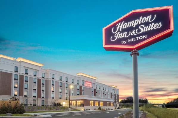 A Hampton Inn & Suites by Hilton hotel with a large illuminated sign, modern architecture, and a well-lit facade. - Hampton Inn & Suites Newburgh Stewart Airport (Newburgh)