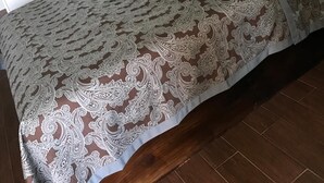 A hotel room with a large bed, a wooden headboard, and a view of the outdoors. - Moonlight Inn (Houston)