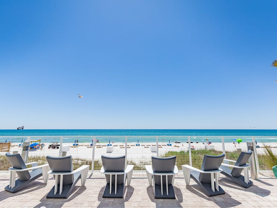 På stranden, hvidt sand, liggestole, parasoller