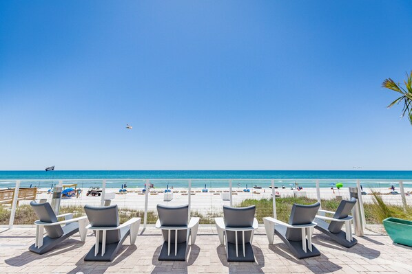 Am Strand, weißer Sandstrand, Liegestühle, Sonnenschirme