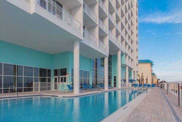 Et hotel med swimmingpool, udendørs siddepladser og moderne arkitektur.