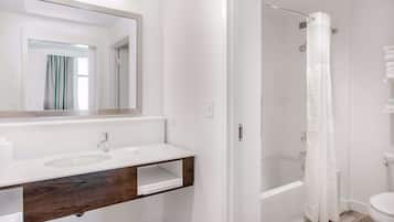 A bathroom with a white sink, mirror, and shower curtain.
