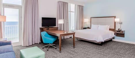 Una habitación de hotel con cama, escritorio, silla y televisor.