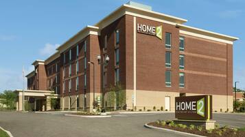 Home 2 Suites by Hilton offers a welcoming entrance with a covered walkway and landscaped area.
