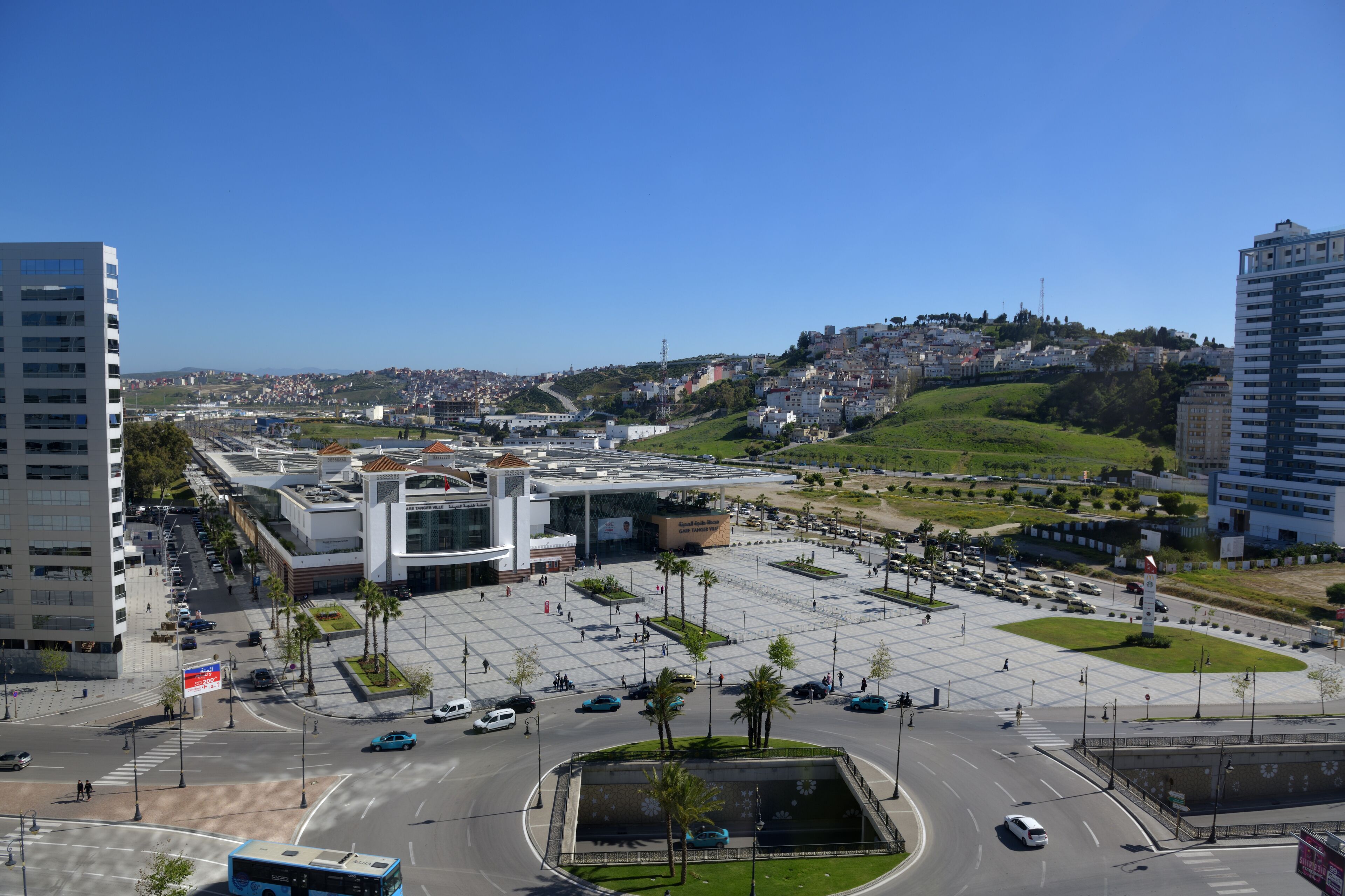 A large, modern building with a central plaza and surrounding parking.