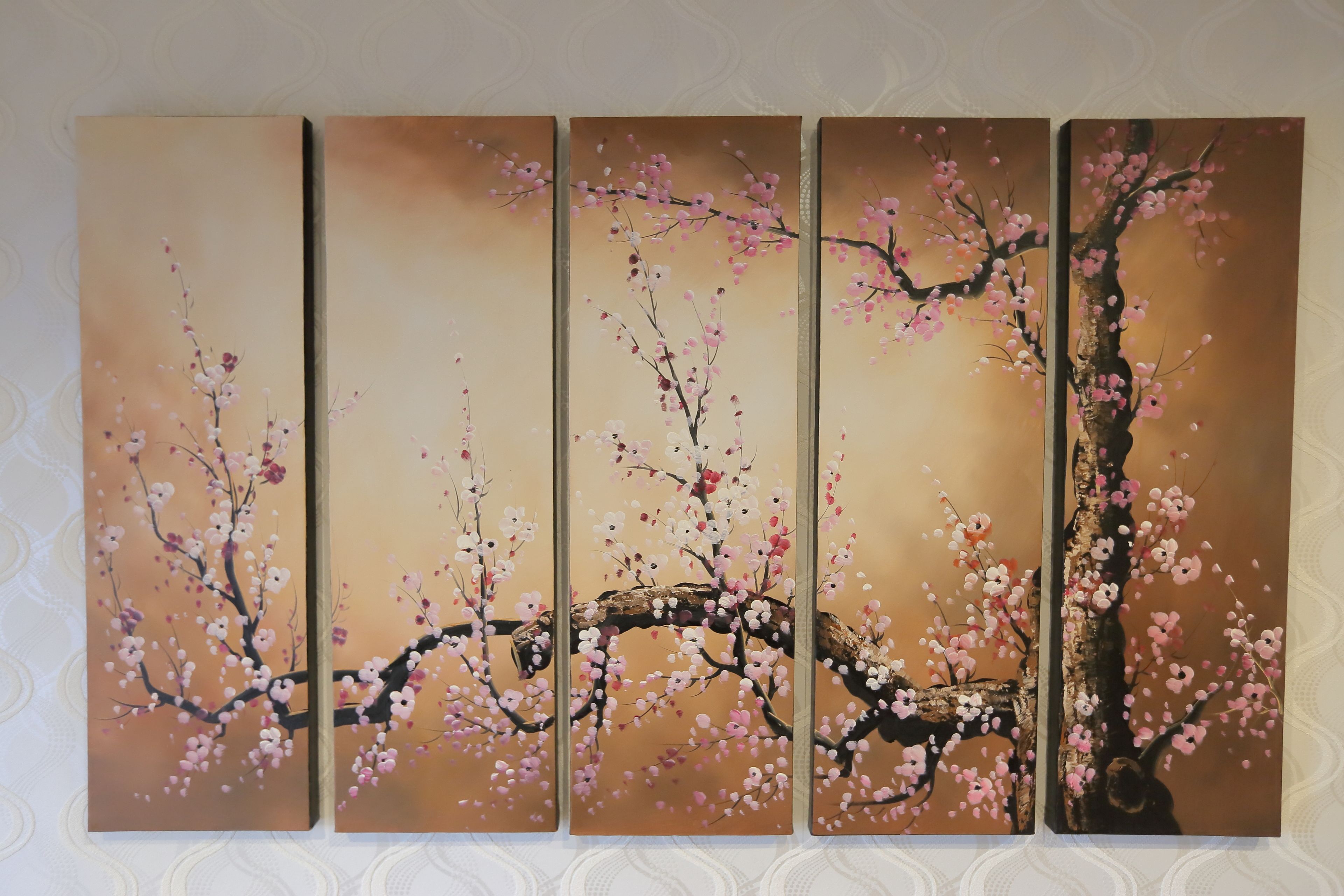 Cuatro paneles de una pintura de flores de cerezo en una pared.