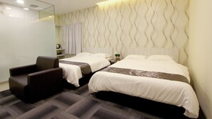 Una habitación de hotel con dos camas, una silla y un espejo.
