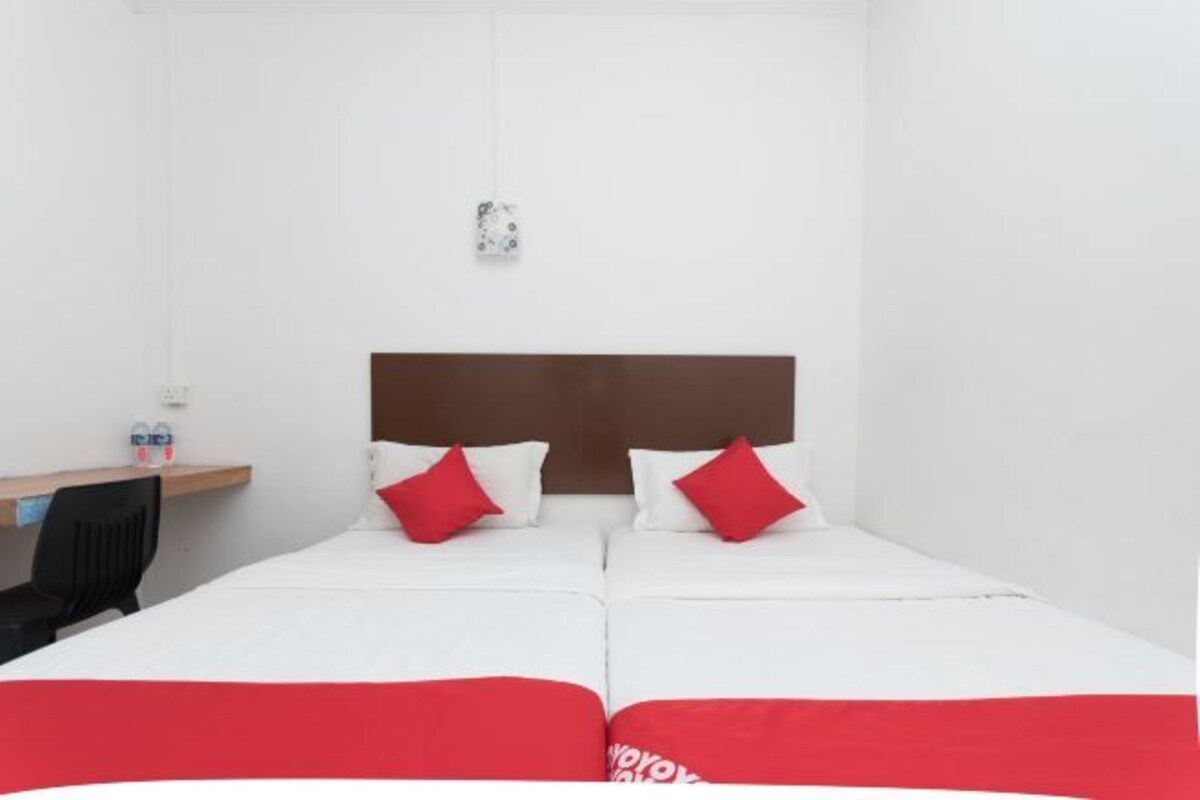 A hotel room with a bed, a desk, and a chair.