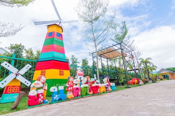 A colorful windmill and various whimsical sculptures along a pathway.