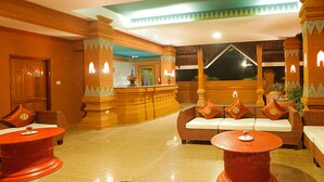 A lobby with a reception desk, seating area, and a view of the outside.