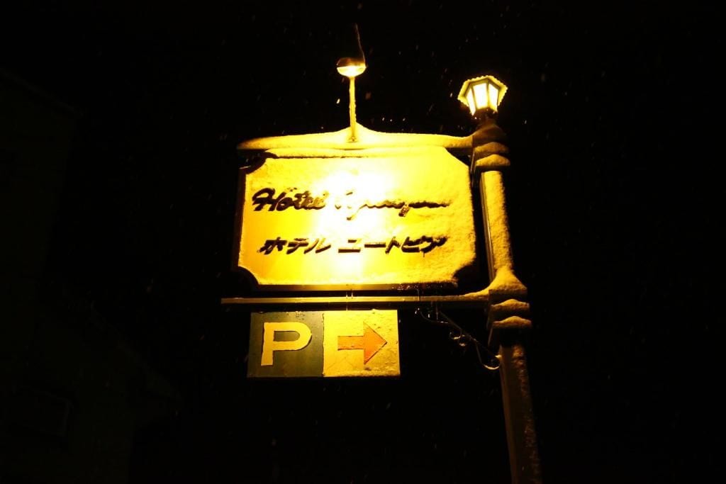 A sign with Japanese text and a directional arrow, likely indicating hotel parking.