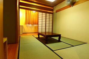 A traditional Japanese room with tatami flooring, a low wooden table, and sliding shoji doors. - Utopia Naeba (Yuzawa)
