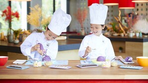 Two individuals in chef uniforms at a kitchen counter with various ingredients and utensils. - Hoshino Resorts RISONARE Kohamajima (Taketomi)