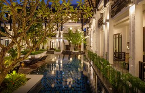 A hotel courtyard with a swimming pool, outdoor seating, and lush greenery. - Thai Akara - Lanna Boutique Hotel (Chiang Mai)