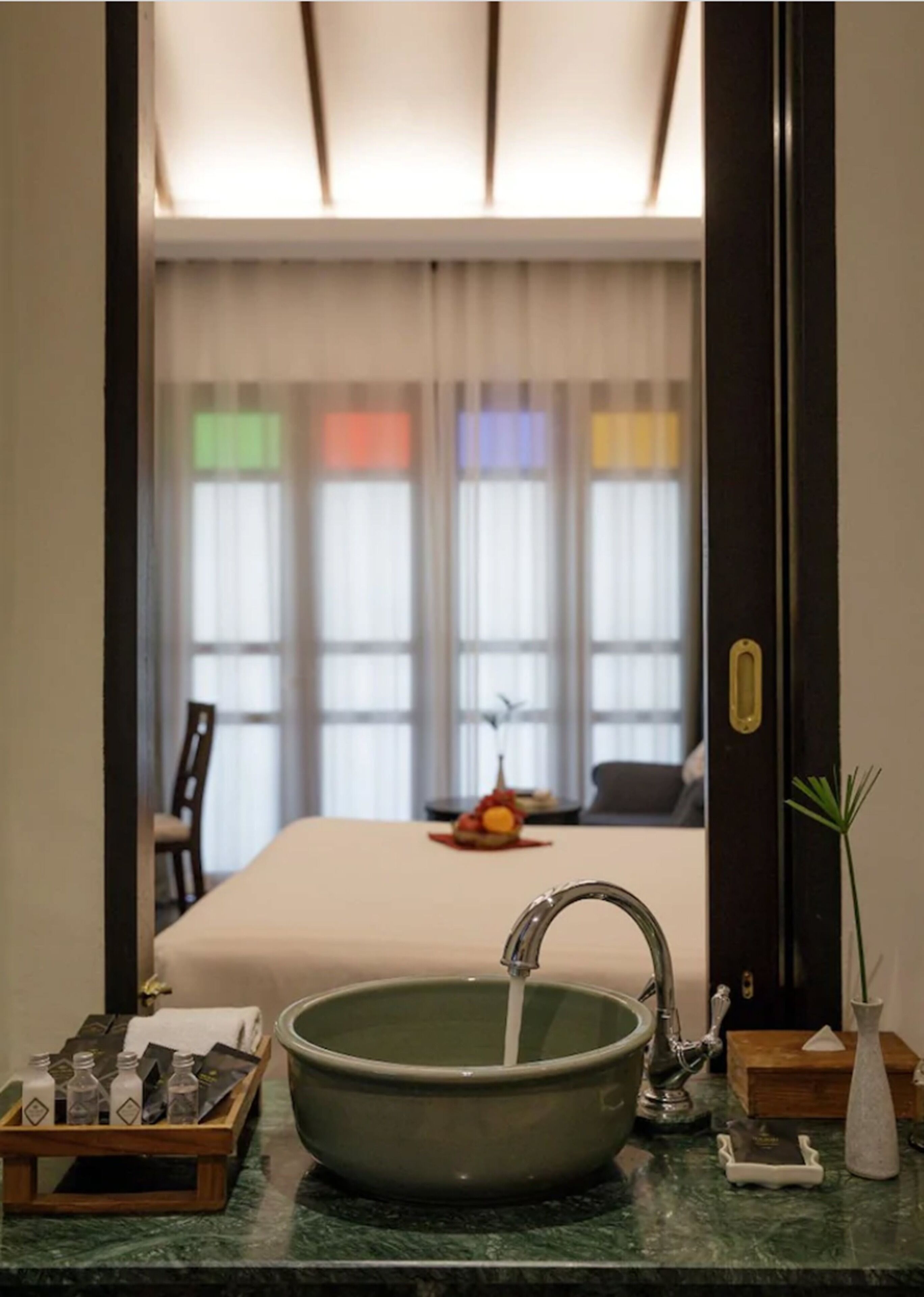 A bathroom with a sink, mirror, and toiletries.