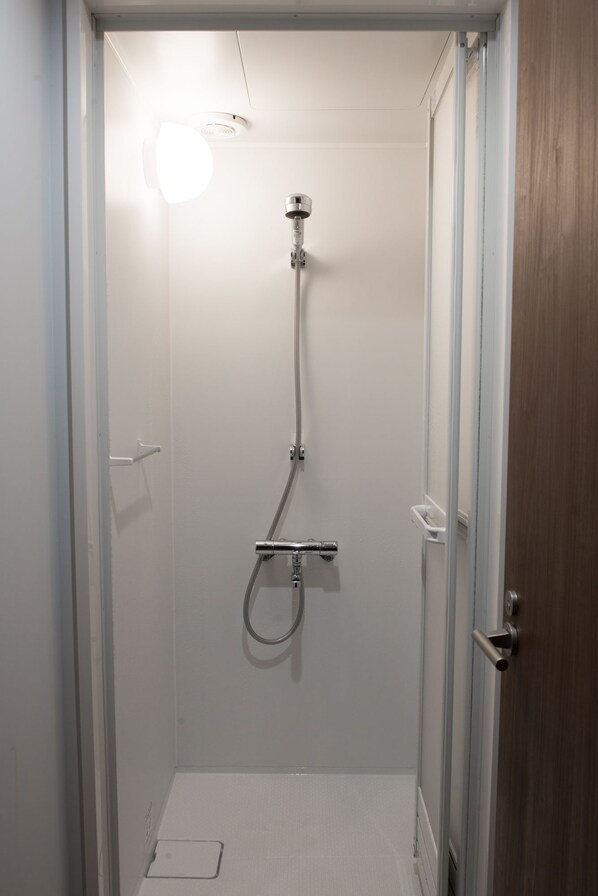 A small, enclosed shower area with a handheld showerhead and a handheld shower attachment. - Book Tea Bed GINZA - Hostel (Tokyo)