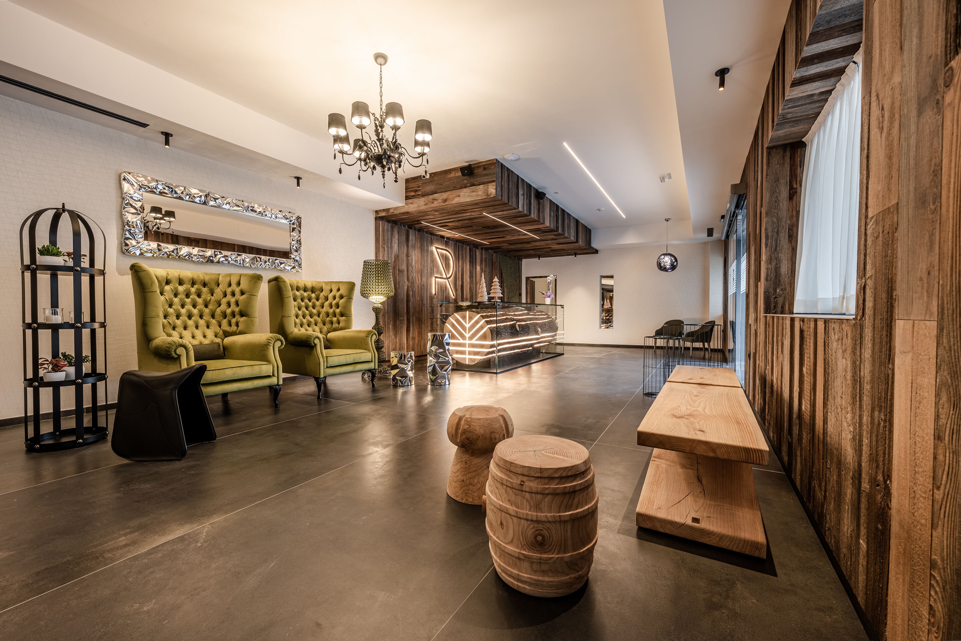 Un interior moderno con un sofá verde, detalles de madera y una araña.