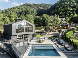 A modern building with a pool and outdoor seating.