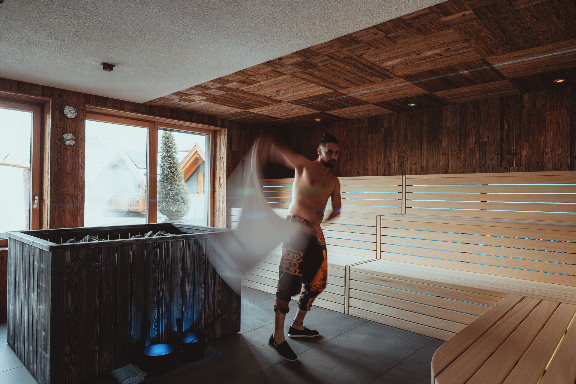 A sauna room with wooden walls and a bench.