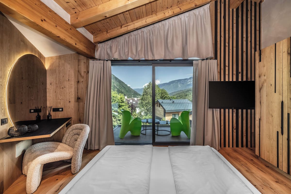 Une chambre avec un grand lit, un bureau, une chaise et un téléviseur.