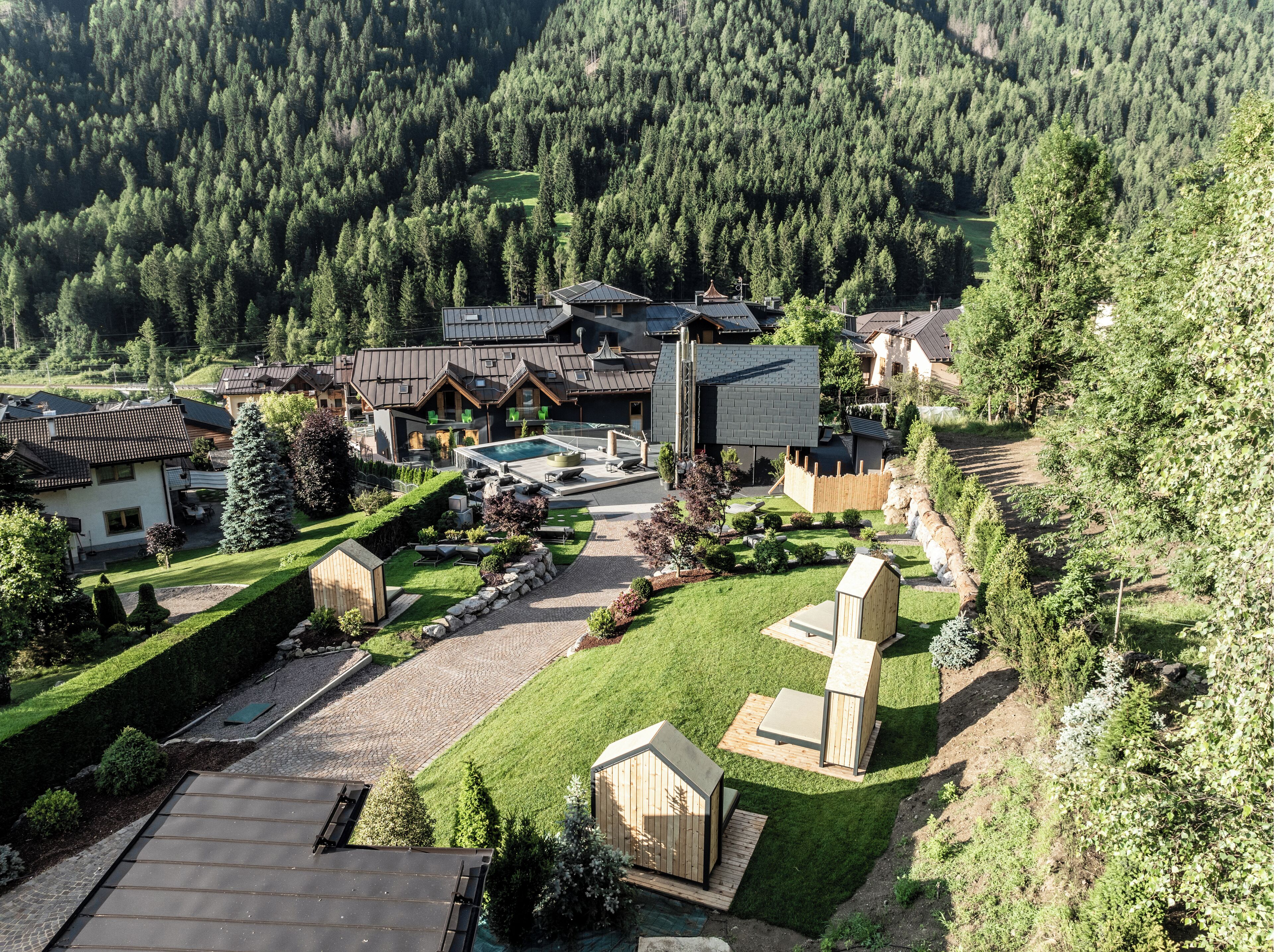 Un complexe hôtelier comprenant plusieurs bâtiments, une piscine et un jardin bien entretenu.