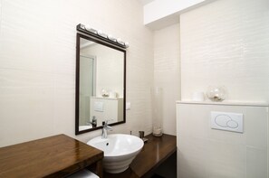 A modern bathroom with a large mirror, a sink, and a vanity. - Apartments Carmelitta (Dubrovnik)