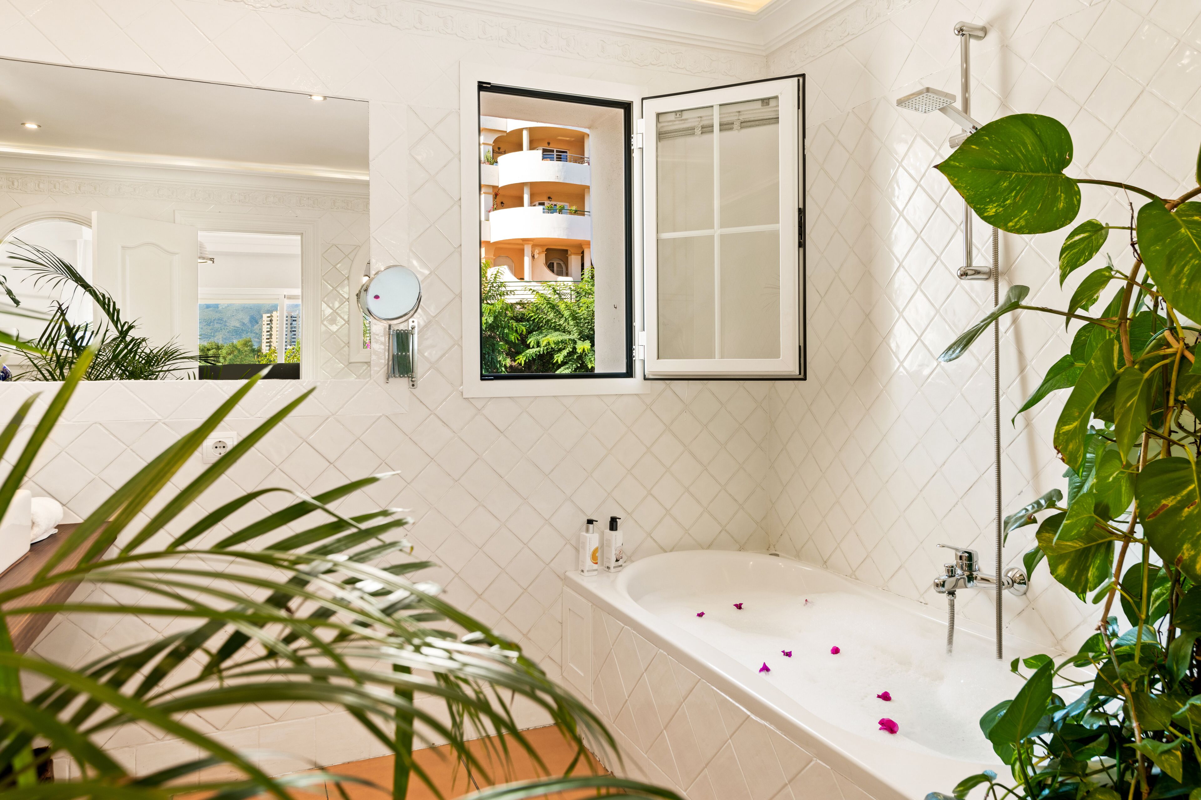 Ein modernes Badezimmer mit Badewanne, Dusche und einem großen Spiegel.