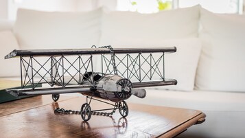 Een modelvliegtuig op een houten tafel in een kamer met een witte bank.