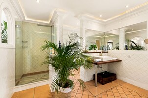 Een moderne badkamer met een douche met glazen wand, een wastafel met handdoekrek en een grote spiegel.