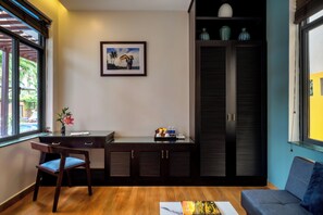 A compact living space with a desk, chair, and sofa. A framed picture hangs on the wall. - Serene River Villa (Da Nang)