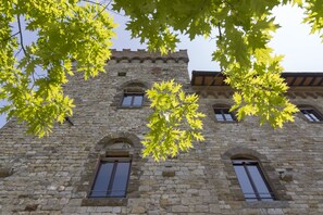 Een gebouw van steen met boogvensters en een toren.