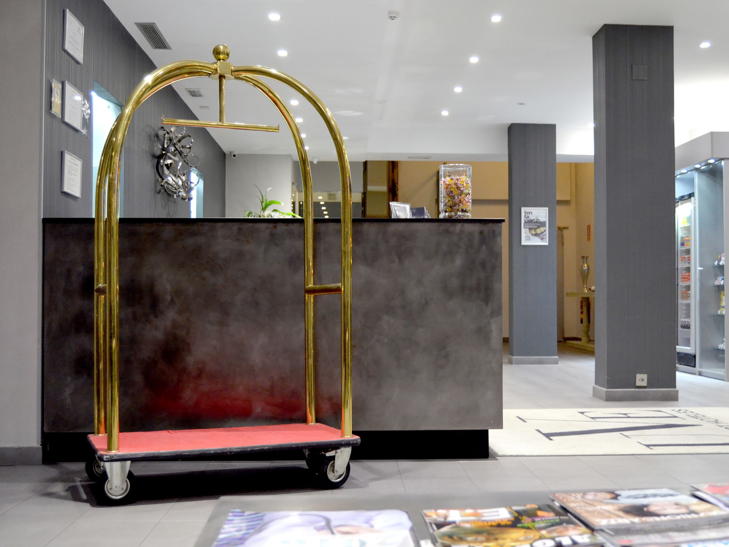 A reception area with a gold-framed desk, a red cushioned bench, and a floor with directional arrows.