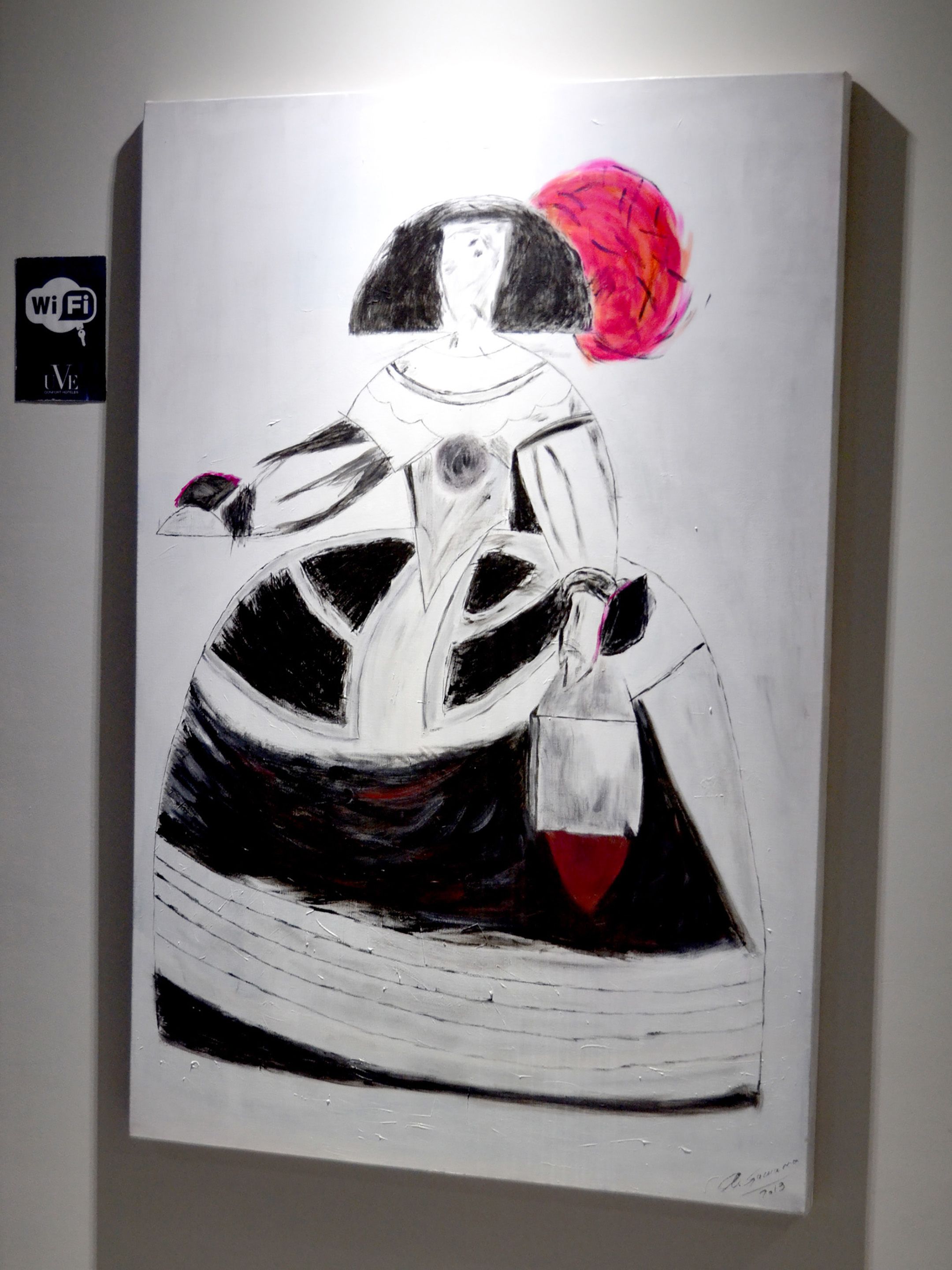 A painting of a figure in a dress with a large pink flower on the head, displayed on a wall.