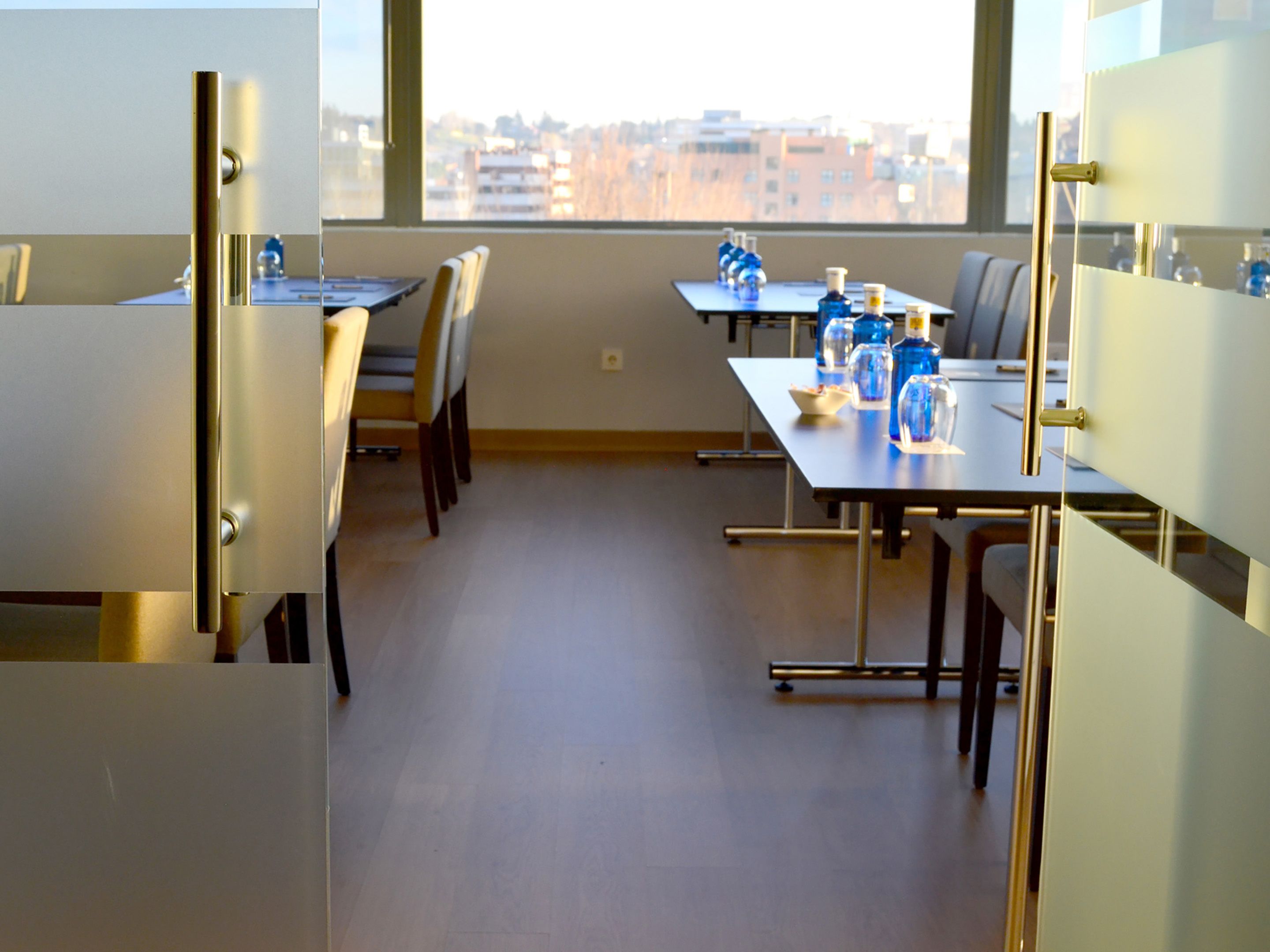 A conference room with tables, chairs, and water bottles.