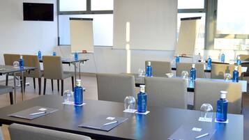A conference room with tables, chairs, and presentation screens.